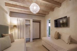a living room with a couch and a flat screen tv at Casa Vendicari Boutique Hotel in Noto