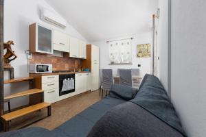 a living room with a couch and a kitchen at Apartman Mely in Nova Vas