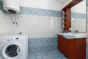 a bathroom with a washing machine and a sink at Apartman Mely in Nova Vas