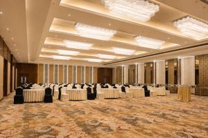 a ballroom with tables and chairs and chandeliers at Park Inn by Radisson Ayodhya in Ayodhya