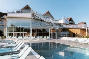 a resort with a swimming pool and lounge chairs at Selma Spa in Sunne
