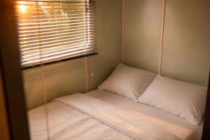 a small bed in a room with a window at Gezellig Chalet Ardennen The Secret View in Amblève
