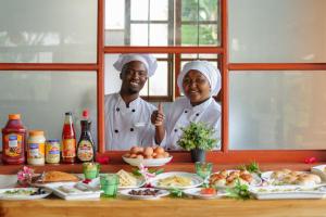 a man and woman standing in front of a table of food at Tanzania Safari Lodge in Arusha