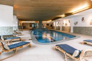 a pool in a hotel with lounge chairs around it at Hotel Bären in St. Moritz