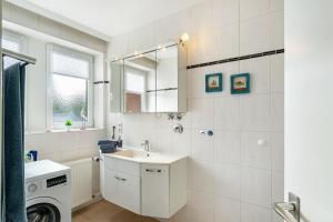a white bathroom with a sink and a washing machine at Südstadtquartier 108 in Wilhelmshaven +14 photos