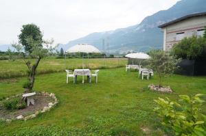 a group of tables with umbrellas in a field at La CASA DI OLIVER in Pian Camuno