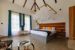 a bedroom with a king sized bed and a living room at Tanzania Safari Lodge in Arusha