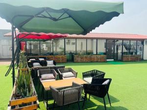a group of tables and chairs under a large umbrella at Hotel Lotus castle in Bathinda