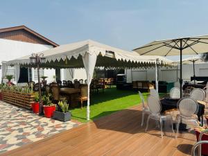 a patio with tables and chairs under a white canopy at Hotel Lotus castle in Bathinda