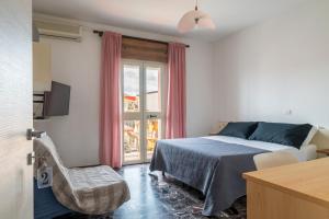 a bedroom with a bed and a chair and a window at B&B Cardedu in Cardedu