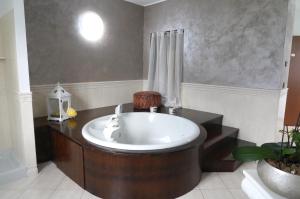 a bathroom with a bath tub with a sink at La CASA DI OLIVER in Pian Camuno +14 photos