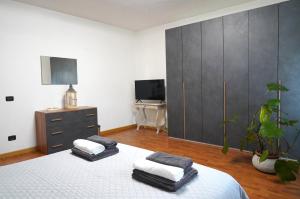 a bedroom with a bed and a dresser and a tv at La CASA DI OLIVER in Pian Camuno