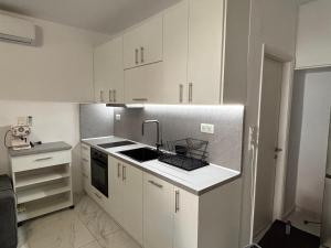 a small kitchen with white cabinets and a sink at Vila Amore in Asprovalta +17 photos