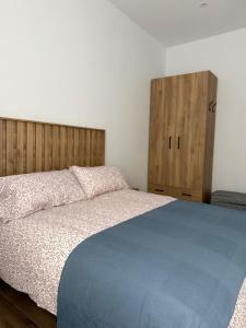 a bedroom with a bed and two wooden cabinets at Rincon de Toledillo in Plasencia