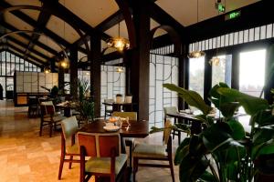 a dining room with tables and chairs and plants at ALOR VALLEY HUZHOU in Huzhou