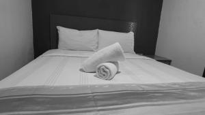 a black and white photo of a bed with two towels at HWKl in Kuala Lumpur