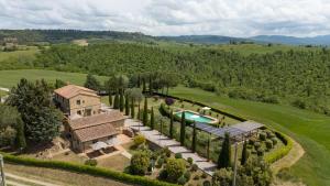 an aerial view of a mansion with a pool and trees at Villa Campriano by VacaVilla in Pienza