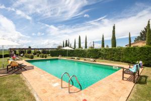 a swimming pool in a yard with two chairs at Villa Campriano by VacaVilla in Pienza +62 photos