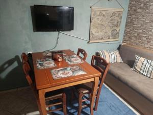 a small table and chairs with a couch and a television at Αγρόκτημα Βερνικο in Paráplati