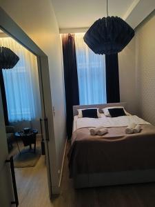 a bedroom with a large bed with two windows at apartament centrum-rynek Gorzów in Gorzów Wielkopolski +1 photo