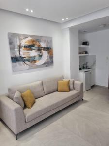 a living room with a couch and a painting at Irides Apartments in Megalochori +17 photos