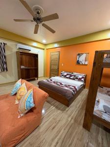 a bedroom with two beds and a ceiling fan at Surf Front Villa Samar in Maydolong