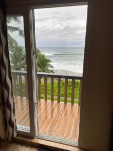 a door to a balcony with a view of the ocean at Surf Front Villa Samar in Maydolong