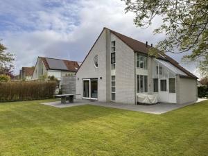 a house with a bench in front of a yard at Villa Relax Ooghduyne - Dünen Golf und Spa bei Beach & more in Julianadorp