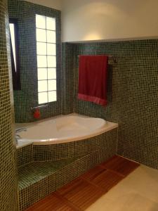 baño con bañera y toalla roja en Los Bancales, en Frigiliana