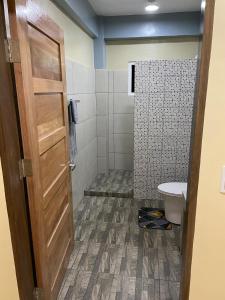 a bathroom with a toilet and a door at Surf Front Villa Samar in Maydolong