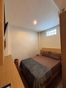 a small bedroom with a bed and a window at Sendja Residence in Semarang