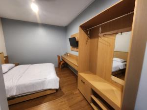 a small bedroom with a bed and a desk at Sendja Residence in Semarang