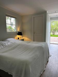 a bedroom with a white bed and a window at Orangeriet Björkelund in Skövde