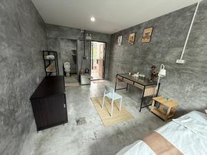 a living room with a desk and a room with a bed at Bird Nest Hostel in Ko Tao