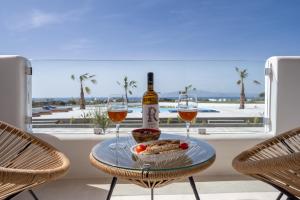 a table with a bottle of wine and two glasses at Kastraki Riviera Suites in Kastraki