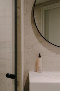a bathroom with a mirror and a soap dispenser on a counter at Boutique Hotel Herbergh Amsterdam Airport FREE PARKING in Badhoevedorp