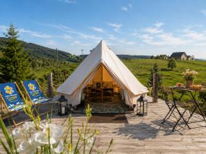 a bell tent with two chairs and a table at Zimnik Camp in Lipowa