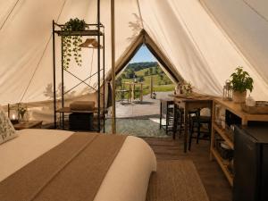 a tent with a bed and a table and chairs at Zimnik Camp in Lipowa