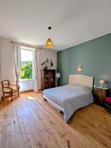 a bedroom with a bed and a large window at L'Ecrin de Pommayrac - Appartement Nature, au coeur d'un centre équestre in Verzeille