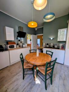 a kitchen and dining room with a wooden table and chairs at L'Ecrin de Pommayrac - Appartement Nature, au coeur d'un centre équestre in Verzeille