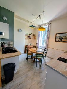 a kitchen and dining room with a table and chairs at L'Ecrin de Pommayrac - Appartement Nature, au coeur d'un centre équestre in Verzeille +7 photos