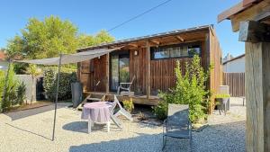 a house with a table and chairs in front of it at EcoKub T3 Indépendant Proche plages et lac in Soustons