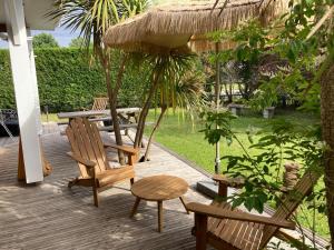 a patio with chairs and a table and an umbrella at Villa ALoha in Carcans