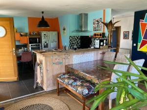 a kitchen with a table and a counter top at Villa ALoha in Carcans