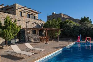 AmigdhalokeFálion的住宿－Villa Kimothoe with Private Pool, only 20 min to Elafonissi Beach，一个带两把椅子的游泳池和一个游泳池滑梯