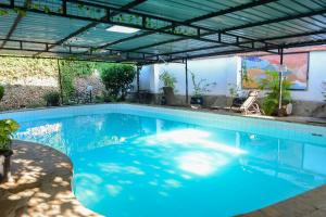 a large swimming pool with a pergola over it at Nyali Garden Escape Villa in Mombasa +44 photos