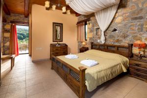 a bedroom with a bed and a stone wall at Villa Kimothoe with Private Pool, only 20 min to Elafonissi Beach in AmigdhalokeFálion