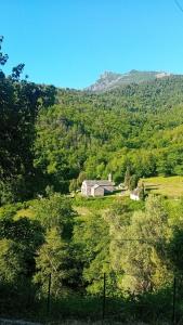 a barn in a field with a mountain in the background at Mini-maison indépendante vue montagne- Corse in Poggio-Marinaccio