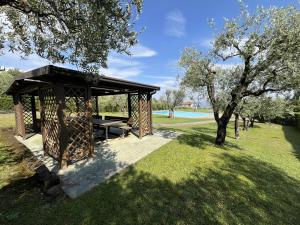 a picnic shelter in a park with a tree at Garda Prestige Retreat in Moniga