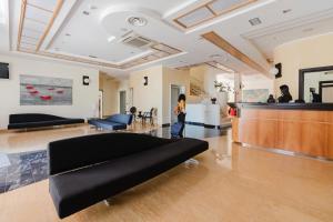 a woman is standing in a lobby with a couch at Cerri Hotel in Castellammare del Golfo +66 photos